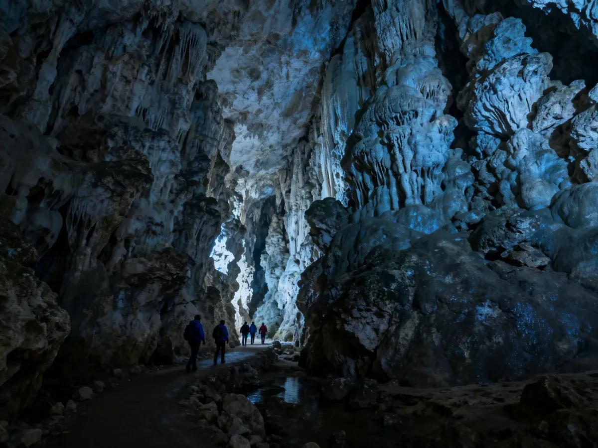 Visitors exploring an underground cave with rock formations
